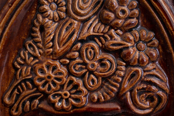 Terra cotta tile on a romanian heating stove, abstract texture, soft focus close up