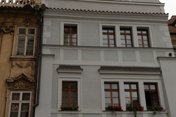 A pristine white building featuring an abundance of large windows adorned with vibrant, colorful flowers placed beautifully within each window
