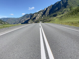 Fototapeta premium rural landscape with asphalt road and mountains under blue sky in summer