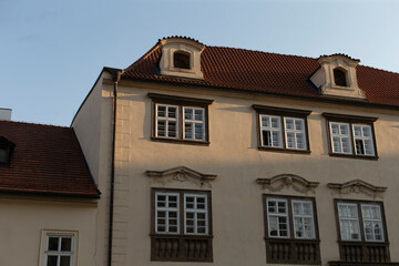 A charming white building featuring a striking red roof and numerous large windows that allow plenty of natural light inside