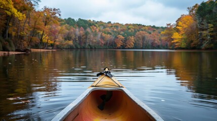 Fototapeta premium A serene lake surrounded by autumn foliage, with a lone kayak drifting peacefully on the water