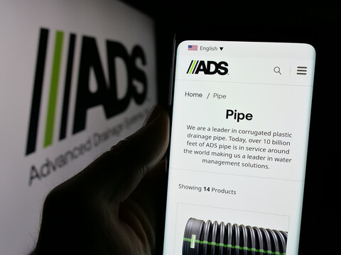 Stuttgart, Germany - 10-08-2024: Person holding cellphone with webpage of US company Advanced Drainage Systems Inc. (ADS) on screen with logo. Focus on center of phone display.