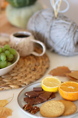 Pumpkins, various food and drinks, fall decorations, books and candles on the table. Fall hygge at home. Selective focus.