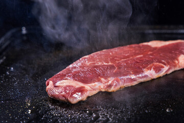生の牛肉を鉄板で焼く様子