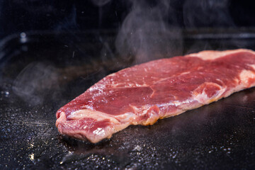 生の牛肉を鉄板で焼く様子