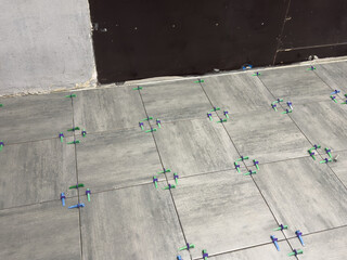 Laying Ceramic Tiles. Worker putting tiles on the balcony.