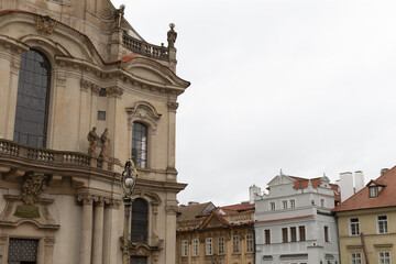 Fototapeta premium A large and impressive building featuring a spacious balcony is beautifully surrounded by a collection of smaller, charming buildings