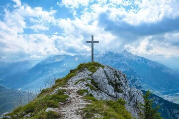 Wooden Cross atop a Mountain Peak with a View of Distant Hills