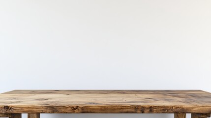 Bare wooden desk in front of a blank white wall with plenty of room for text. A desk for work or study, highlighting the idea of a workspace. 