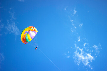 Colored parachute in the blue sky. Parachute.
