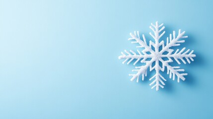 Elegant Winter Wonderland: A Delicate Snowflake on a Serene Sky-Blue Background