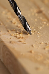 metal drill bit and pine wood board during operation