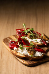Sandwiches with cheese spread, mushrooms, grilled pepper and microgreen pea pods on a board