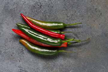 Several hot chili pepper pods on textured background, minimalism