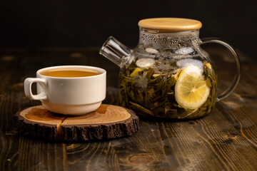 making green tea in a glass teapot with lemon and mint