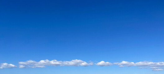 青い空と一列に流れるもくもく雲