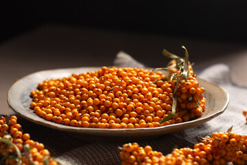 A plate with orange berries stands on a table, close-up