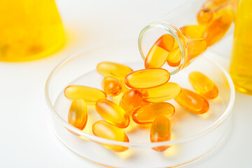 Petri dish with fish oil capsules inside, vitamin D, omega softgels, supplements, keto diet.