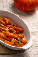 Blush carrots with sauce in a white ceramic dish baked in the oven. A delicious dish for Thanksgiving