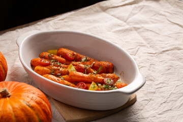 Blush carrots with sauce in a white ceramic dish baked in the oven. A delicious dish for Thanksgiving