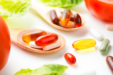 Colorful pills and capsules in wooden spoon with fresh vegetables, Vitamins and supplement