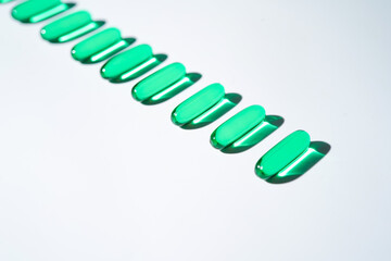 Vitamin E softgel capsules, vitamin D3, fish oil, omega 3, Green oil pills on a white background
