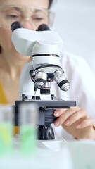 Woman scientist using microscope in laboratory. Microbiology science concept