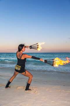 Traditional maya fire dancer at sunset on the beach.  Mexico