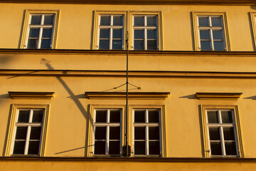 Fototapeta premium There is a striking yellow building that features numerous windows, giving it a vibrant and appealing look from all angles