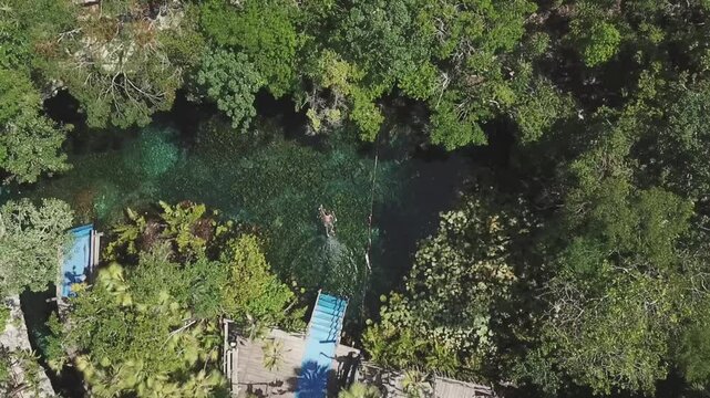 Aerial view of person jumping into cenote Nicte Ha in Parque Dos Ojos, Tulum, Riviera Maya, Mexico