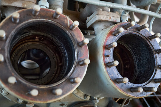 Two piston cylinder chambers of four piston reciprocating faded old fashioned compressor opened for checking and controlling of inner state and repair. Selective focus closeup shot.