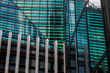 An innovative glass building facade with teal and purple striped reflections creating a vibrant, dynamic atmosphere representing modern design and color play.
