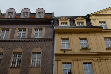 On a rather cloudy day, two distinct buildings stand right next to each other, giving a rather striking appearance against the overcast sky