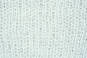 Close-up view of a textured white fabric showcasing a subtle woven pattern in natural light