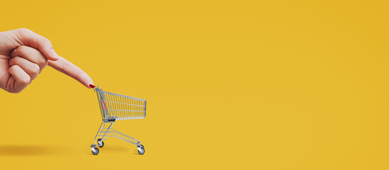 Customer hand pushing a tiny shopping cart