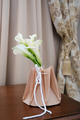 An elegant Calla Lily Bouquet is on table in hotel bedroom.