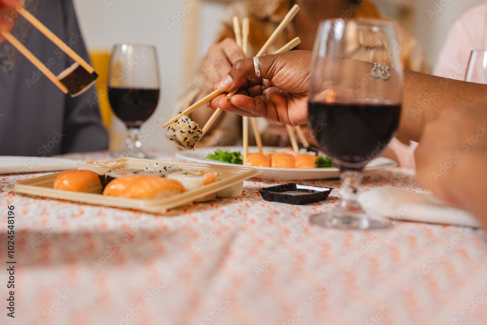 Wall mural friends enjoying christmas dinner with sushi and wine