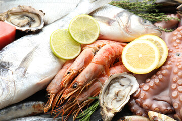 Whole fresh raw octopus and other sea food as background, closeup