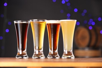 Glasses with different types of beer on wooden table, closeup