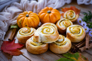 Autumn buns. Sweet buns with pumpkin. Buns with pumpkin filling on a wooden table. Close-up