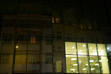 A large building adorned with numerous windows radiates vibrant light during the enchanting night hours, illuminating the surroundings