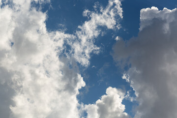 Fototapeta premium Backdrop to the soft white cloud. Blue sky with scattered fluffy white clouds. The clouds vary in size and shape, some are denser and more defined while others are wispy and spread out. Beauty nature