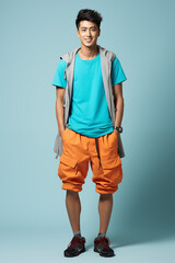 Fototapeta premium Smiling man in a blue color and complementary casual outfit standing in a studio