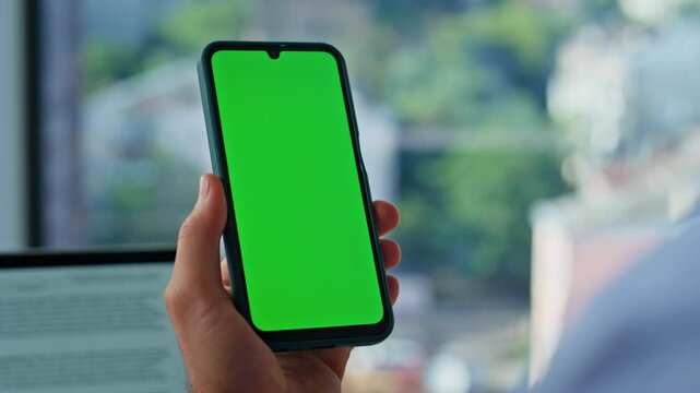 Businessman finger tapping chroma key cellphone browsing at workplace closeup.