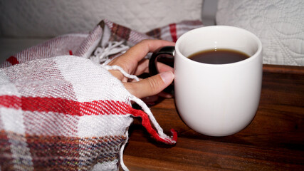 hand with coffee covered with blanket in the morning. High quality photo