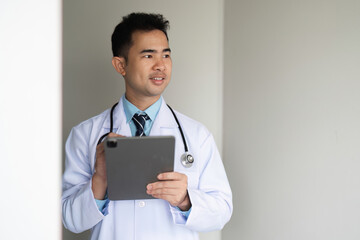 Confident Doctor Holding Tablet in Modern Medical Office with Stethoscope and Professional Attire