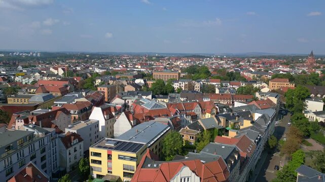halle saale with the red brick building of the library surrounded by trees and houses, in germany. Gorgeous aerial view flight ascending drone
