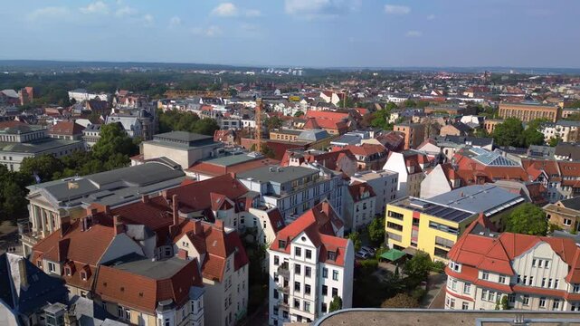 halle saale with the red brick building of the library surrounded by trees and houses, in germany. Stunning aerial view flight rotation to right drone