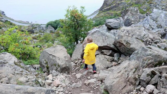 Children and adults, happy family with dog, climbing Festvagtinden via Heiavatnet trail in Norway