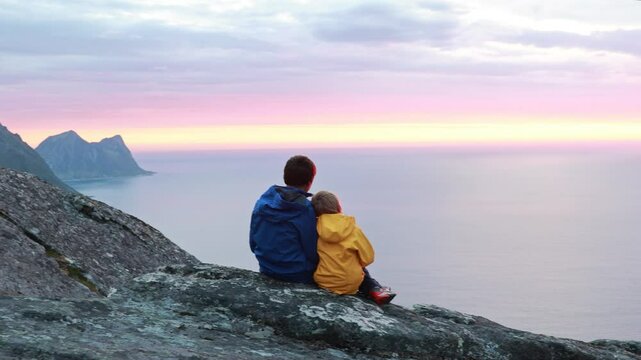 Children and adults, family with dog, hiking Grytetippen trail in Senja, Lofoten on a sunny summer day